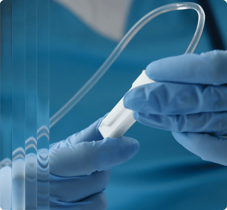 Gloved hands adjusting an intravenous drip.